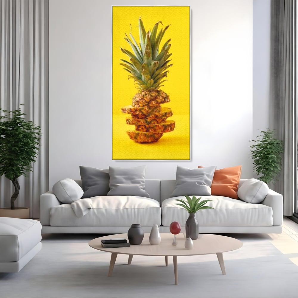 Tablou canvas cu tablou canvas cu ananas feliat, in rama de aluminiu argintiu, pe perete intr-un living